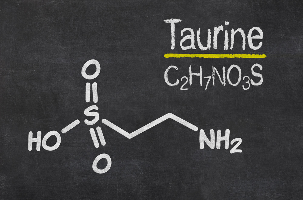 A blackboard appears with the text "Taurine C2H7NO3S" written on it. Below the text is a chemical structure diagram of taurine, displaying its molecular composition with labeled bonds: HO, O=S=O, -C-C-, and NH2.